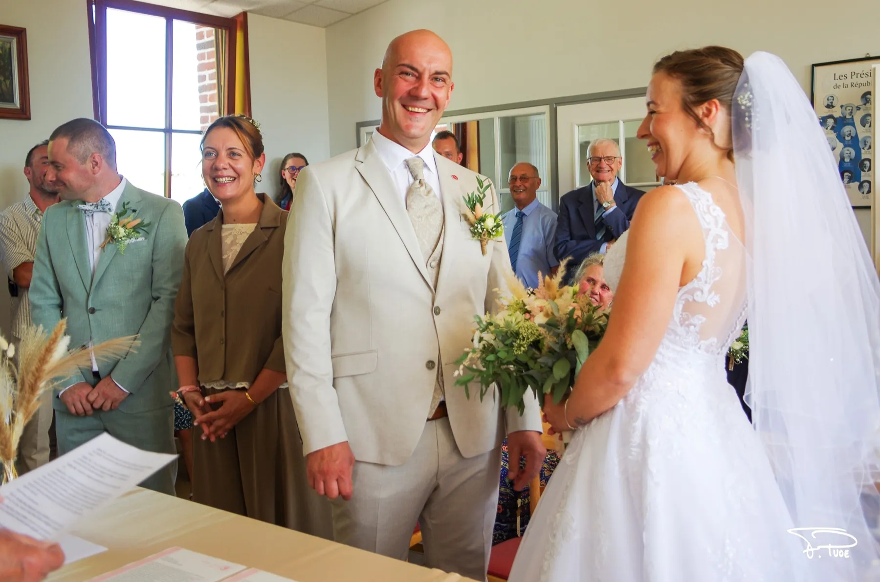 Les mariés souriants à la mairie, entourés de leurs témoins