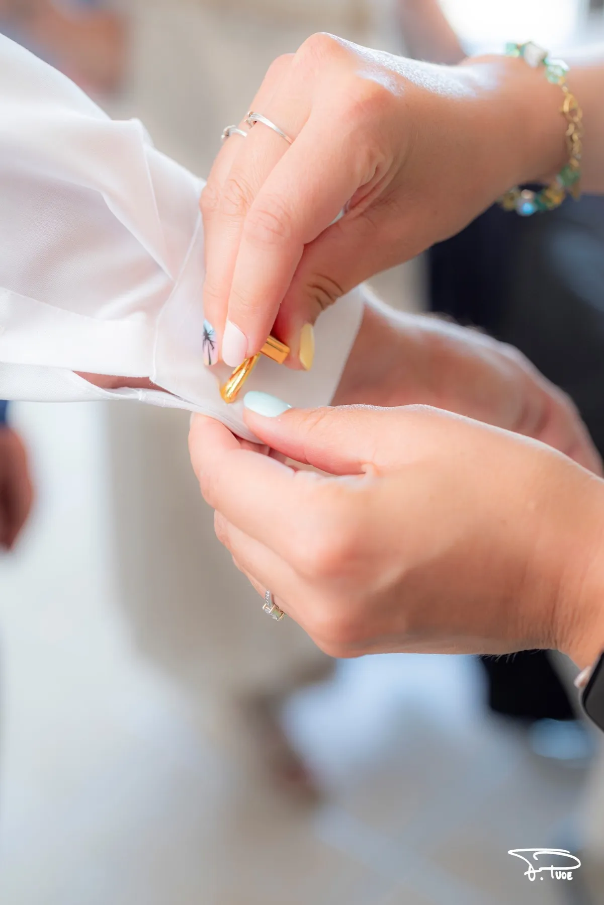 Des mains épinglent la boutonnière du marié