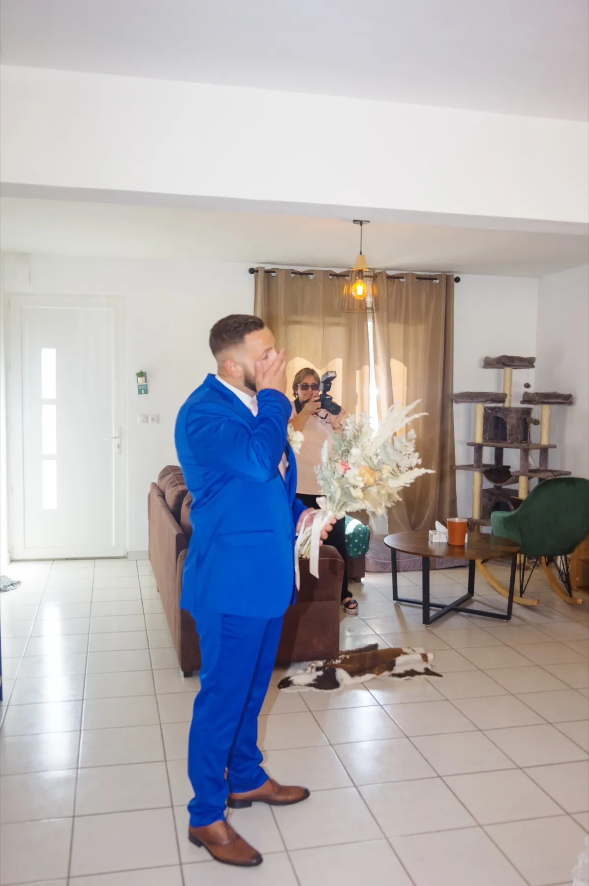Le marié, le bouquet à la main, s’essuie les yeux en découvrant la mariée