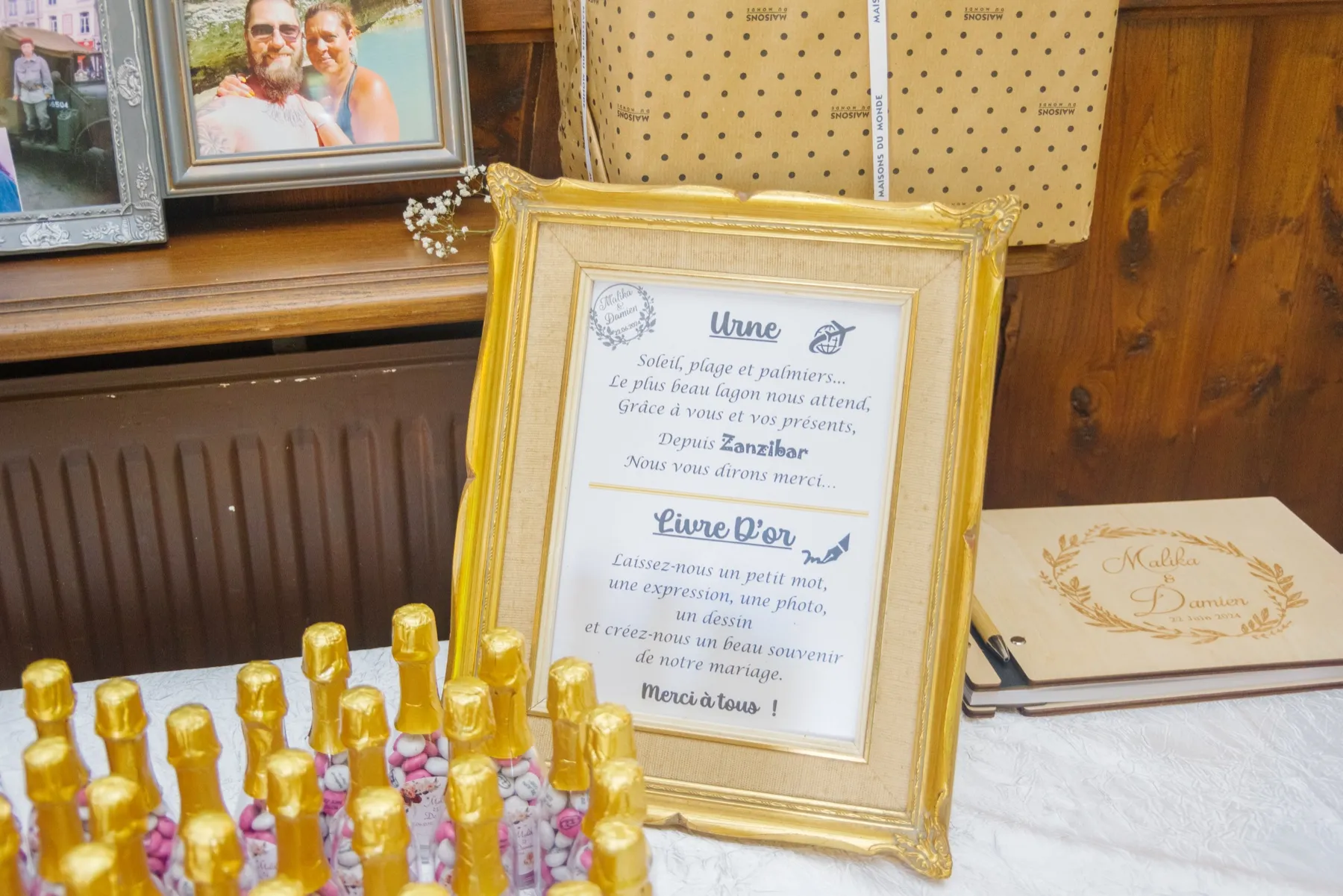Un cadre doré présente l’urne et le livre d’or, près de petites bouteilles dorées