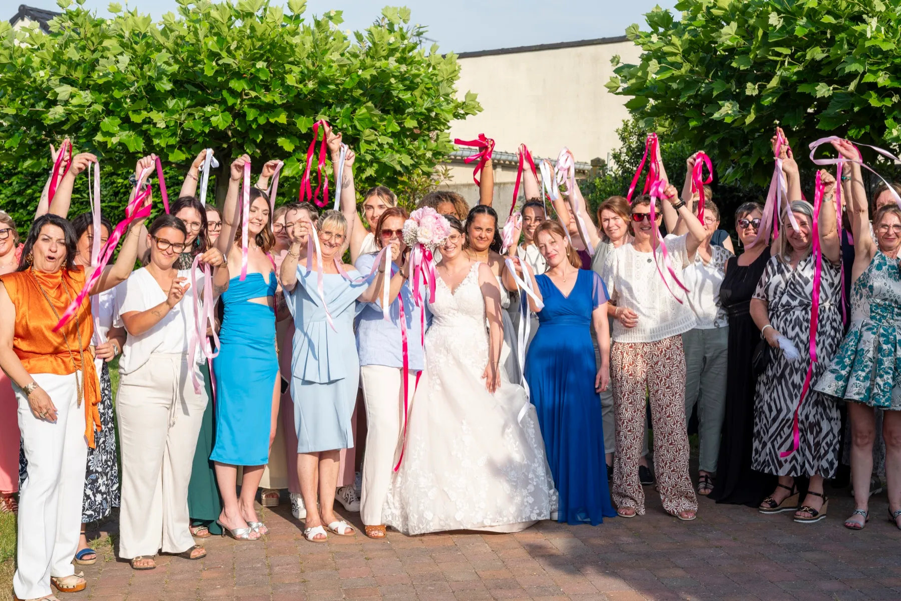 La mariée et ses invitées lèvent leurs rubans en riant