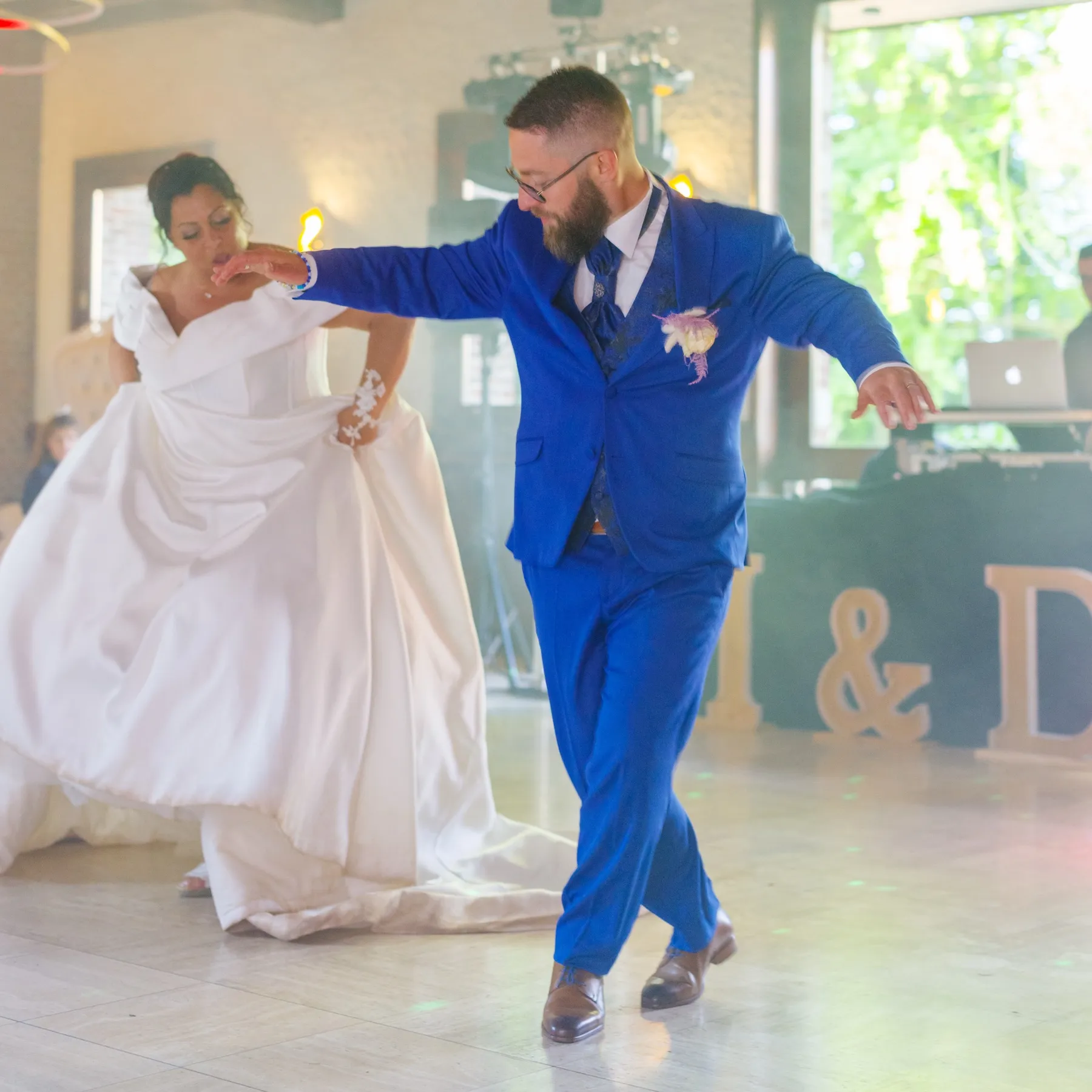 Le marié danse à grands pas, la mariée relève sa robe à côté de lui