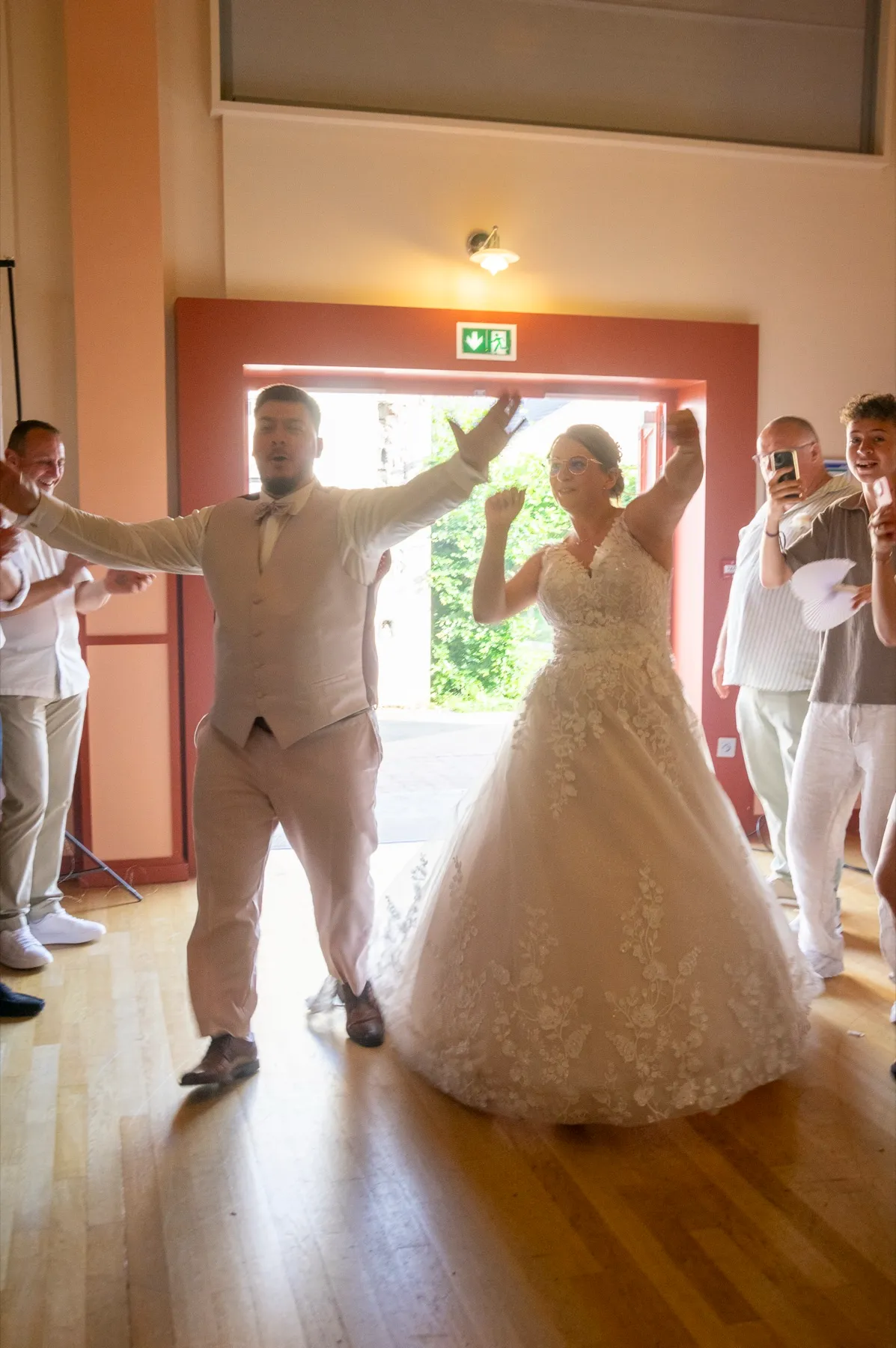 Les mariés entrent dans la salle des fêtes les bras levés