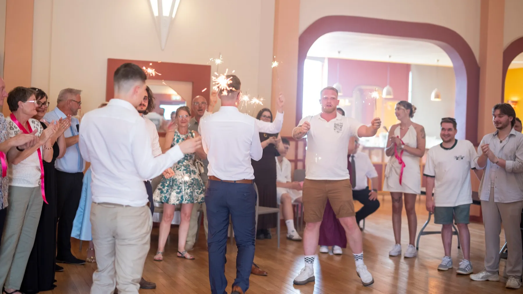 Dans la salle des fêtes, les invités applaudissent un invité qui fait son entrée