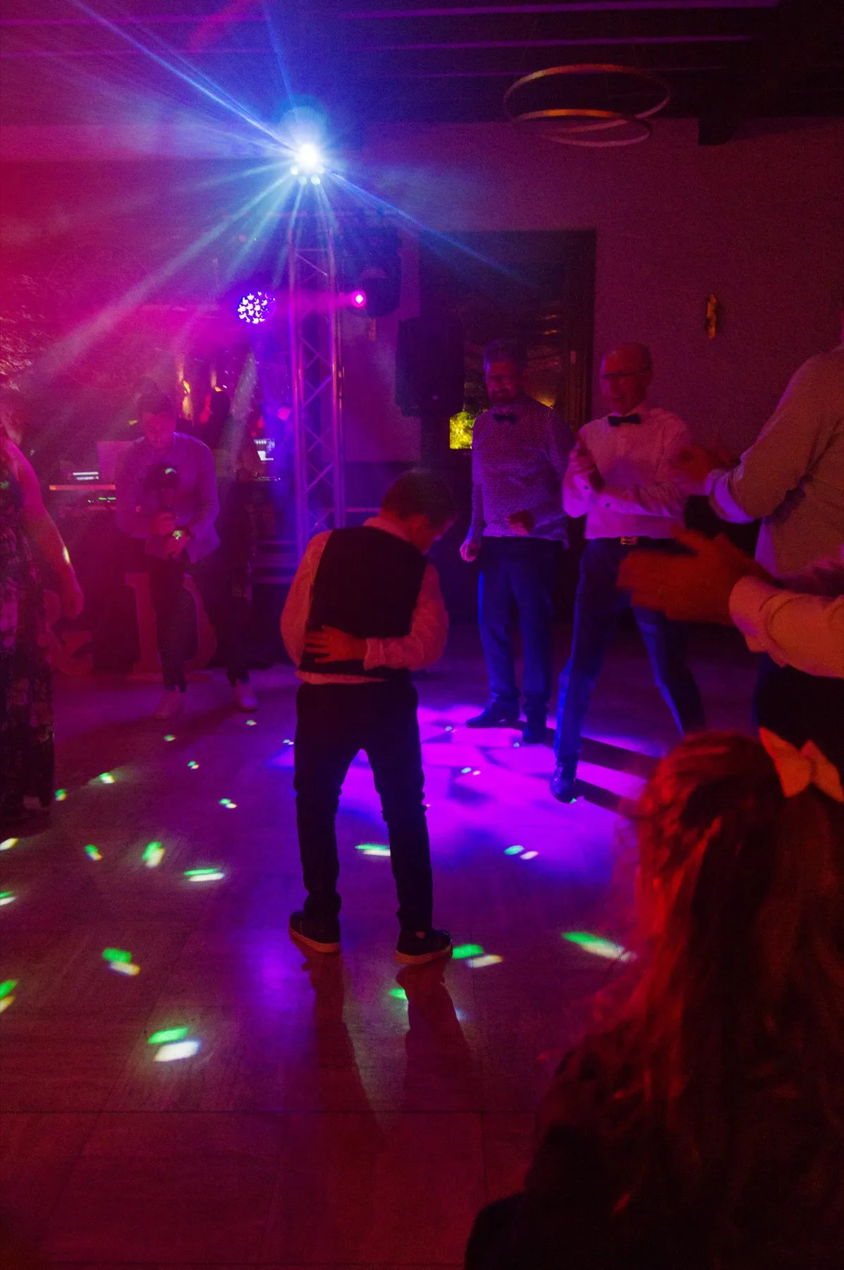 La piste de danse sous les projecteurs roses et bleus, des invités dansent