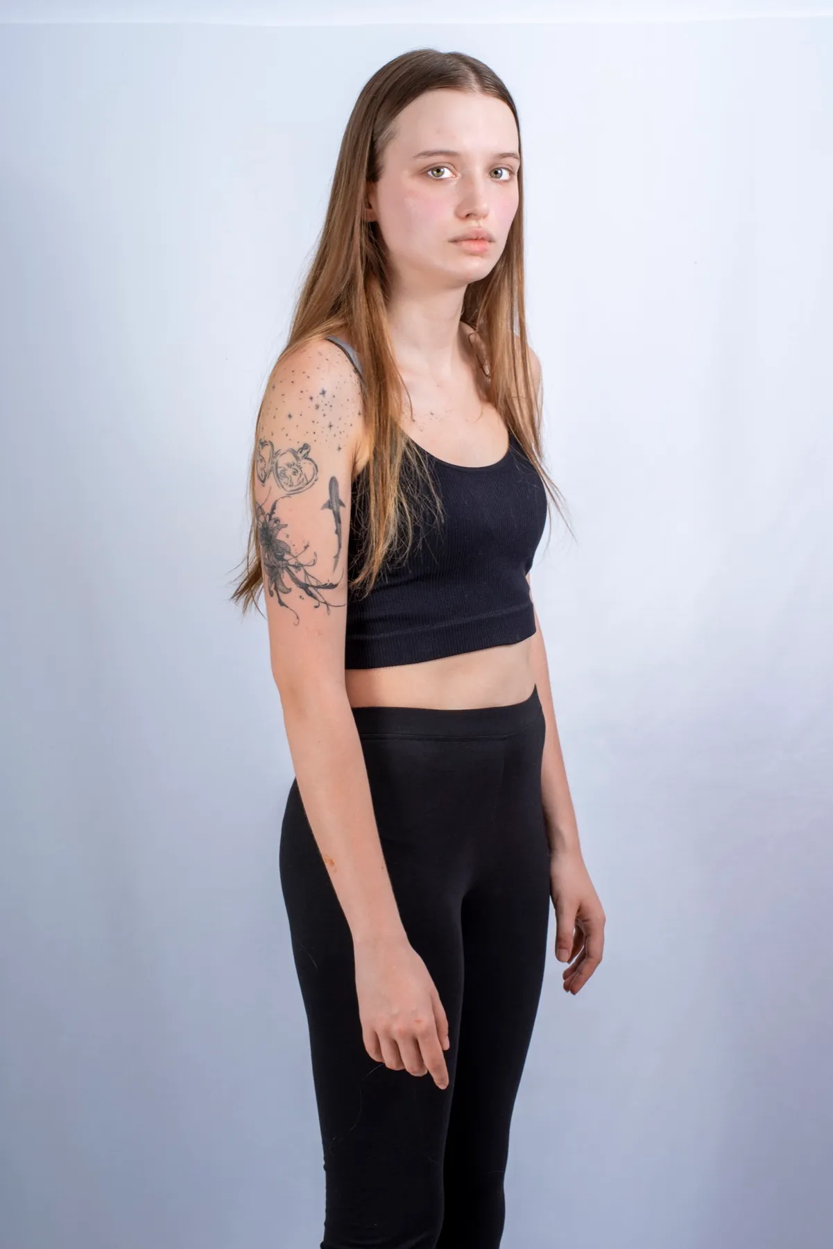 Portrait en pied d’une jeune femme en studio, sur fond clair
